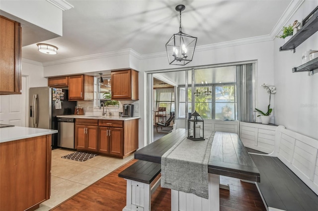 kitchen featuring brown cabinets, stainless steel dishwasher, and light countertops