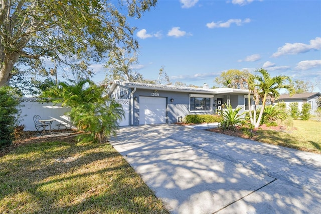 ranch-style home featuring stucco siding, an attached garage, concrete driveway, and a front lawn