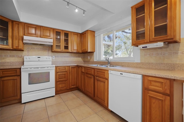 1549 San Christopher Dr, Dunedin, FL 34698 - kitchen with white appliances, under cabinet range hood, brown cabinets, and a sink