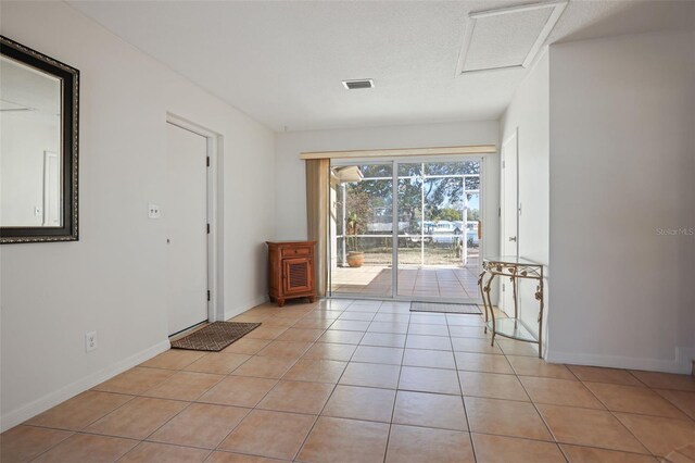 1549 San Christopher Dr, Dunedin, FL 34698 - interior space featuring attic access, baseboards, visible vents, a textured ceiling, and light tile patterned flooring