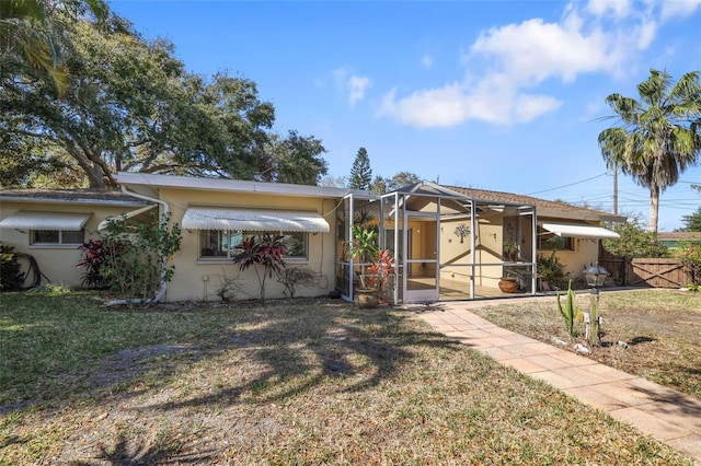 1549 San Christopher Dr, Dunedin, FL 34698 - view of front of house with stucco siding, fence, and a front yard