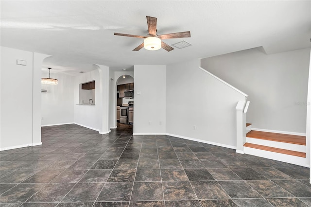 unfurnished room with visible vents, ceiling fan, stairway, and baseboards