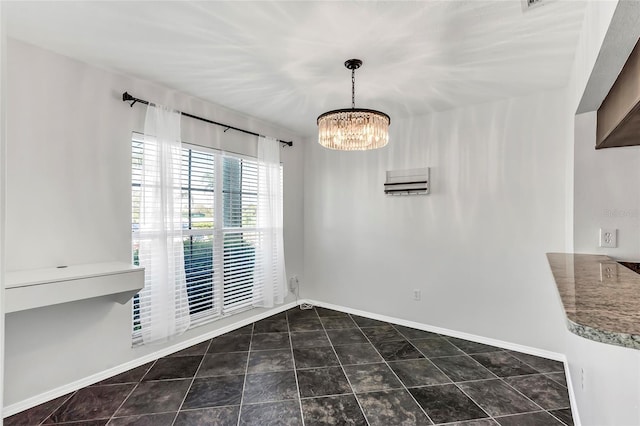 unfurnished dining area featuring baseboards, a chandelier, and tile patterned flooring