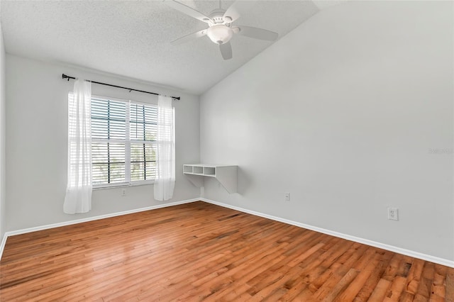 unfurnished room with lofted ceiling, ceiling fan, a textured ceiling, and wood finished floors