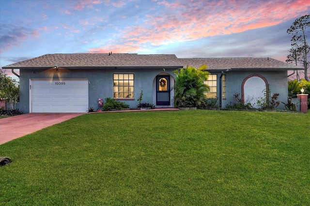 ranch-style house with an attached garage, a front yard, concrete driveway, and stucco siding