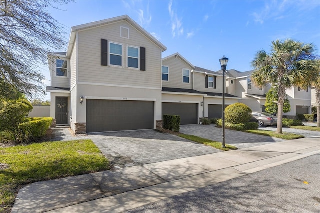 view of front of home featuring a garage, decorative driveway, and stucco siding