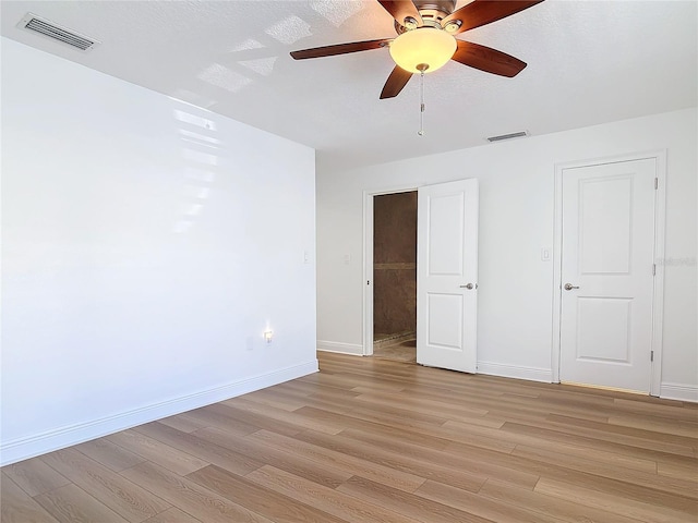 unfurnished bedroom with baseboards, visible vents, ceiling fan, and light wood finished floors