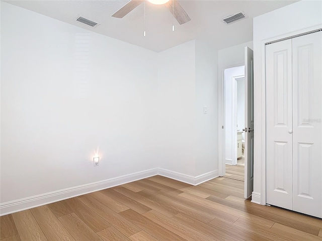 unfurnished bedroom with light wood-type flooring, baseboards, visible vents, and a closet