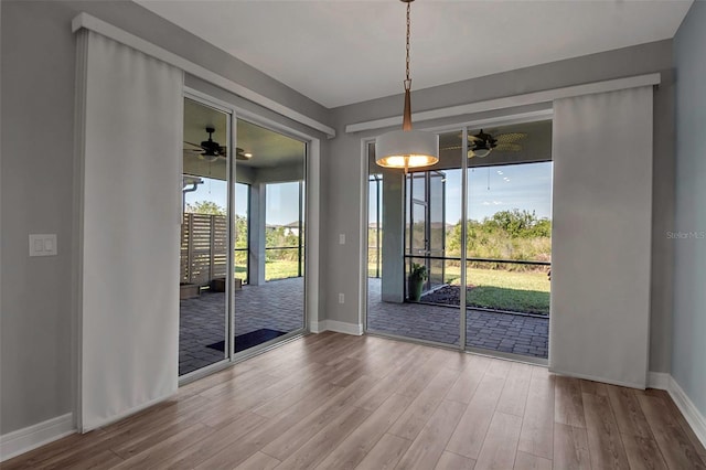 interior space featuring ceiling fan, baseboards, and wood finished floors