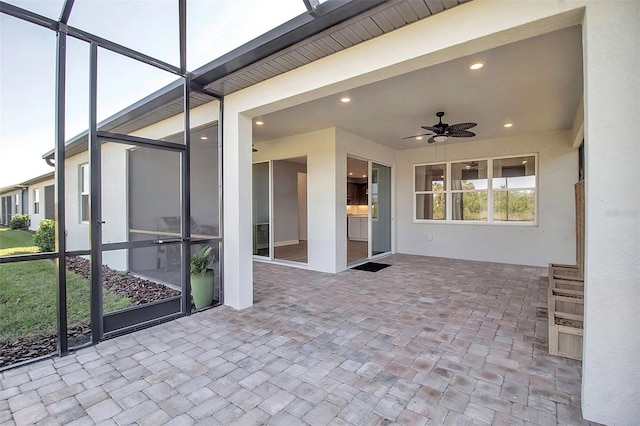 view of patio / terrace featuring ceiling fan and glass enclosure