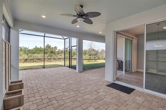 unfurnished sunroom featuring a wealth of natural light and ceiling fan