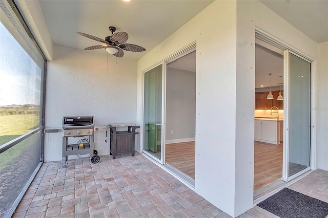 unfurnished sunroom featuring ceiling fan and a sink