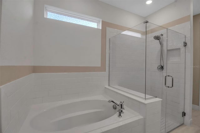 bathroom with a stall shower and a garden tub