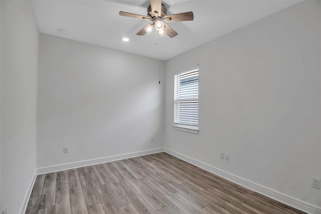 unfurnished room with ceiling fan, wood finished floors, and baseboards