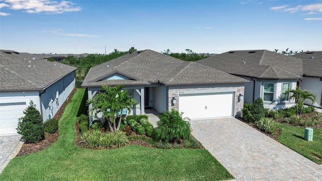 ranch-style house with decorative driveway, stucco siding, a shingled roof, an attached garage, and a front lawn