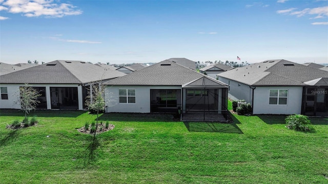 rear view of property with a shingled roof, a sunroom, a lawn, and stucco siding