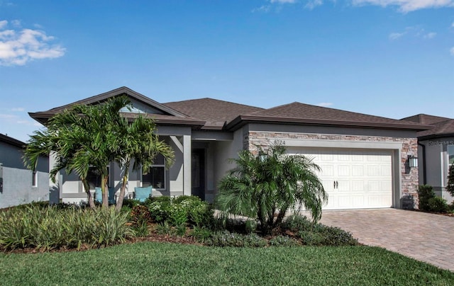 view of front of house with decorative driveway, roof with shingles, stucco siding, a garage, and stone siding