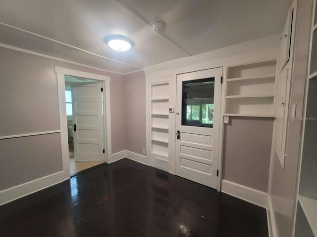 foyer entrance with dark wood-style floors, crown molding, visible vents, and baseboards