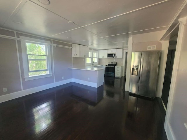 kitchen featuring stainless steel appliances, a peninsula, visible vents, white cabinetry, and light countertops