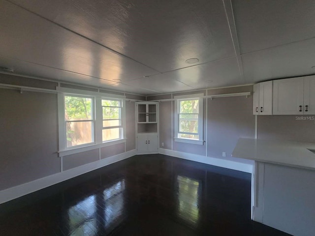 empty room with baseboards and dark wood-style flooring