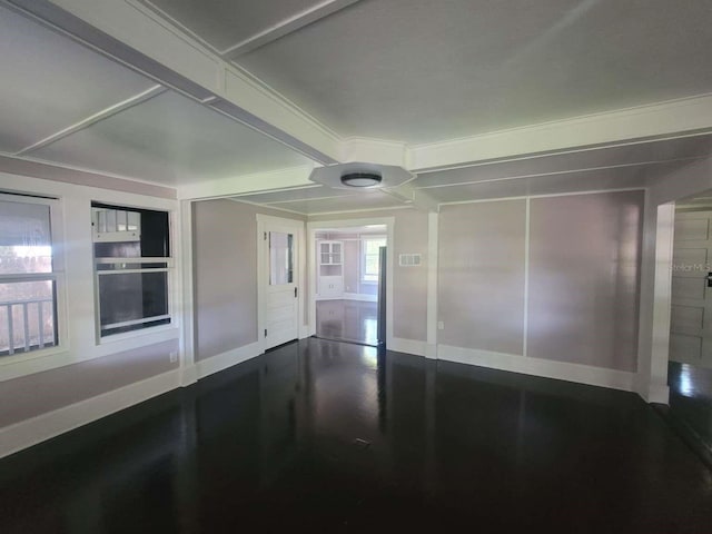 unfurnished room featuring wood finished floors, visible vents, and baseboards