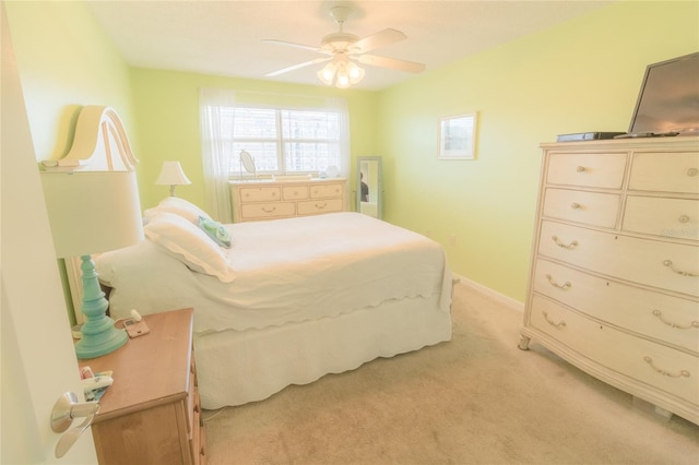 bedroom with a ceiling fan, light colored carpet, and baseboards