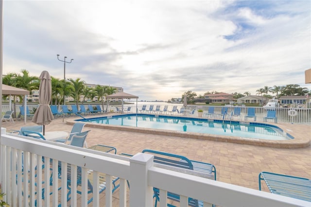 community pool featuring fence and a patio