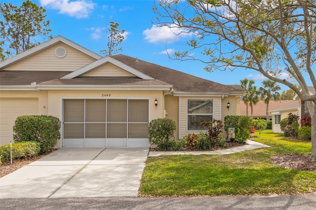 view of front of home featuring roof with shingles, stucco siding, concrete driveway, an attached garage, and a front lawn