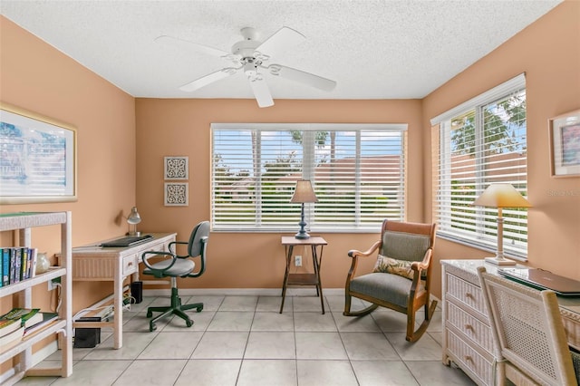 home office featuring tile patterned flooring, baseboards, ceiling fan, and a textured ceiling