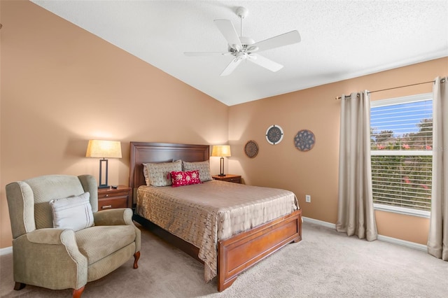 bedroom featuring lofted ceiling, ceiling fan, a textured ceiling, light carpet, and baseboards