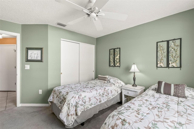 bedroom featuring visible vents, a ceiling fan, a textured ceiling, carpet floors, and a closet