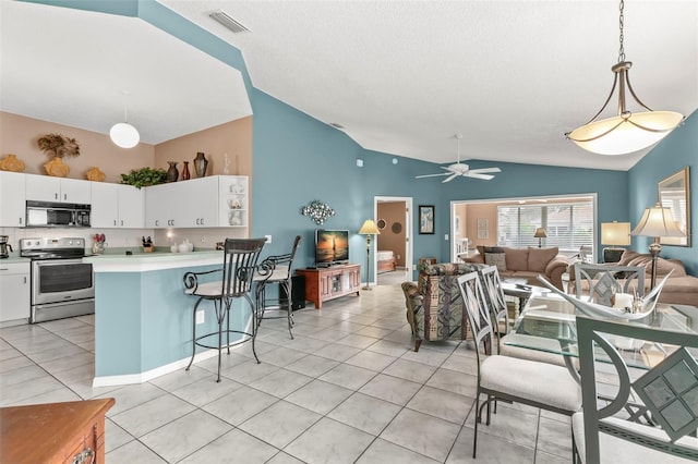 kitchen with visible vents, white cabinets, open floor plan, stainless steel range with electric cooktop, and black microwave