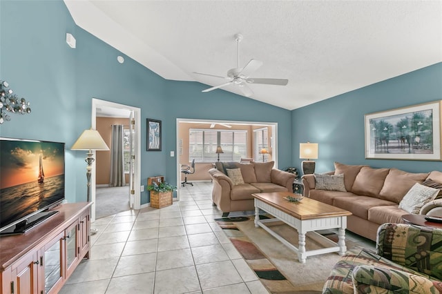 living area featuring ceiling fan, vaulted ceiling, and light tile patterned floors