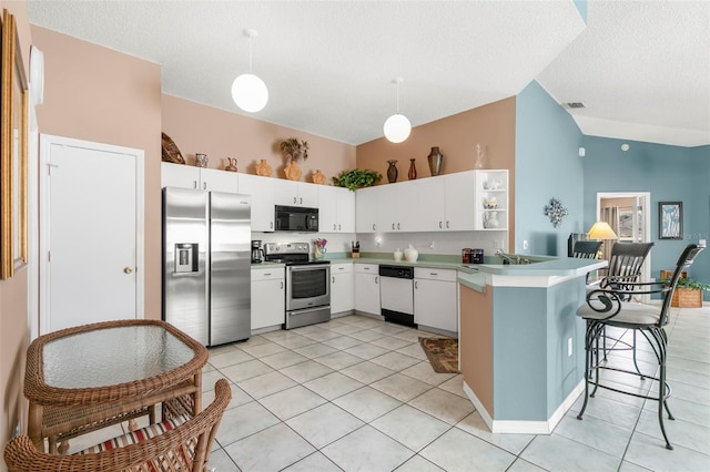 kitchen with visible vents, appliances with stainless steel finishes, white cabinets, vaulted ceiling, and a peninsula