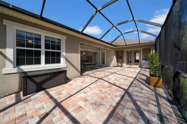 view of patio featuring glass enclosure and ceiling fan