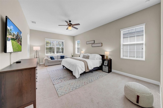 bedroom with baseboards, visible vents, ceiling fan, and light colored carpet