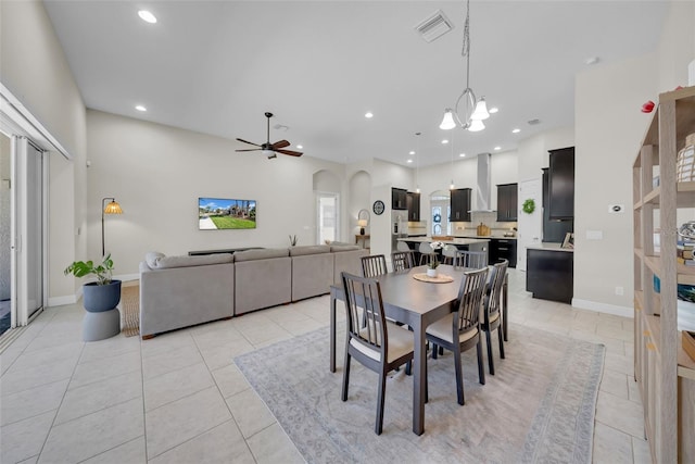 dining room with arched walkways, light tile patterned flooring, recessed lighting, ceiling fan with notable chandelier, and visible vents