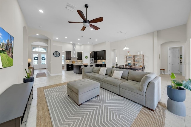 living area with recessed lighting, visible vents, arched walkways, and french doors