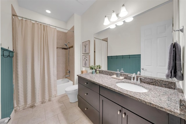 full bathroom with wainscoting, toilet, shower / tub combo with curtain, tile patterned floors, and vanity