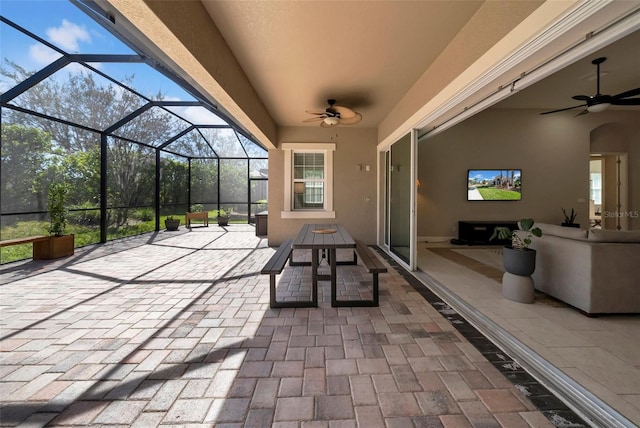 view of patio featuring glass enclosure and a ceiling fan