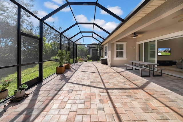 view of patio with glass enclosure and ceiling fan