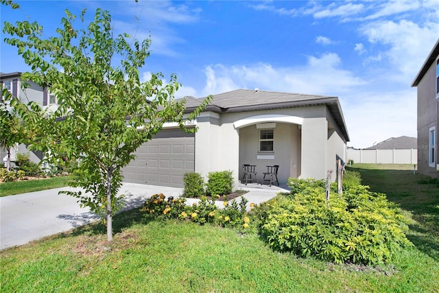 view of front of house with an attached garage, fence, driveway, stucco siding, and a front yard