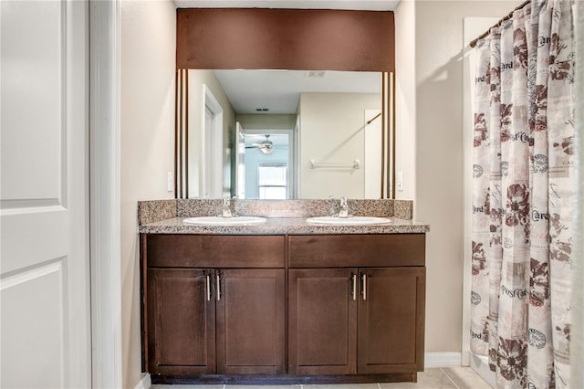 full bath featuring double vanity, curtained shower, a sink, and tile patterned floors