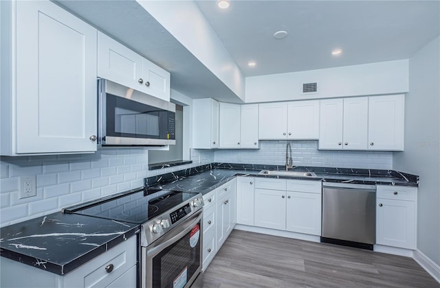 kitchen with white cabinetry, visible vents, appliances with stainless steel finishes, and a sink