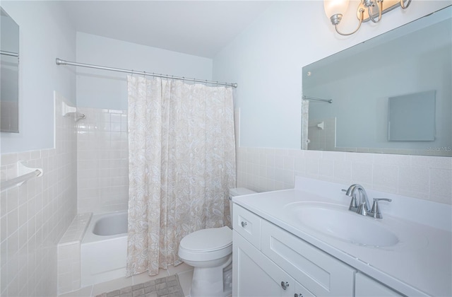 full bath featuring shower / bath combo, wainscoting, toilet, vanity, and tile walls