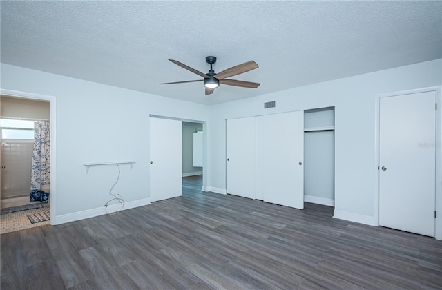 unfurnished bedroom featuring baseboards, a textured ceiling, visible vents, and wood finished floors