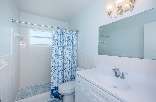 bathroom with toilet, a wainscoted wall, vanity, tile walls, and tiled shower