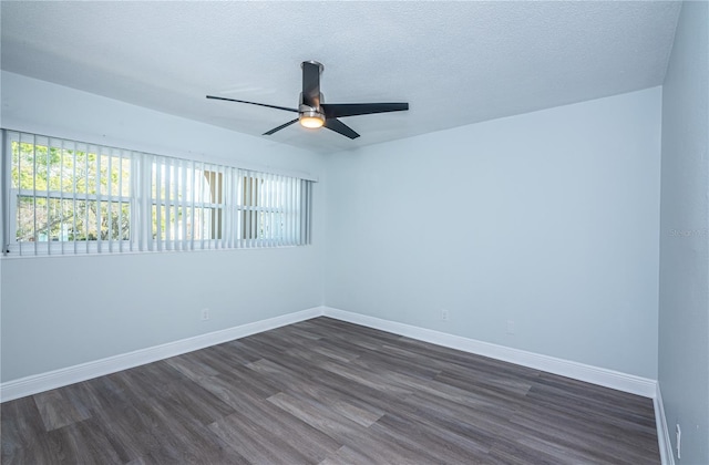 empty room featuring baseboards, dark wood finished floors, and a textured ceiling