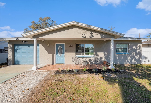 view of front facade with concrete driveway, an attached garage, and stucco siding