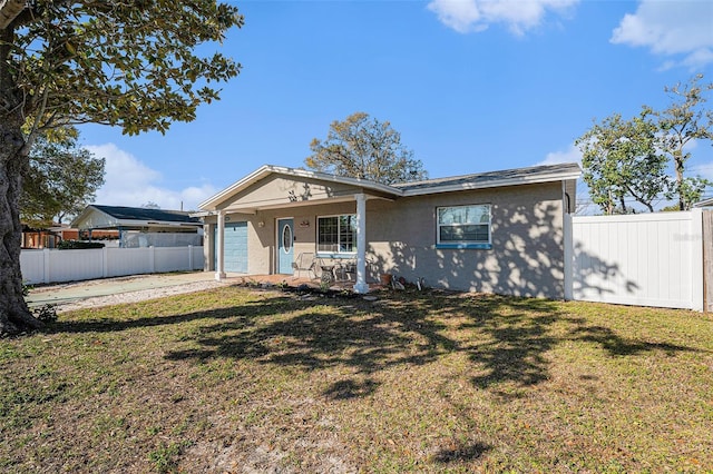 view of front of house featuring a garage, a front yard, covered porch, and fence